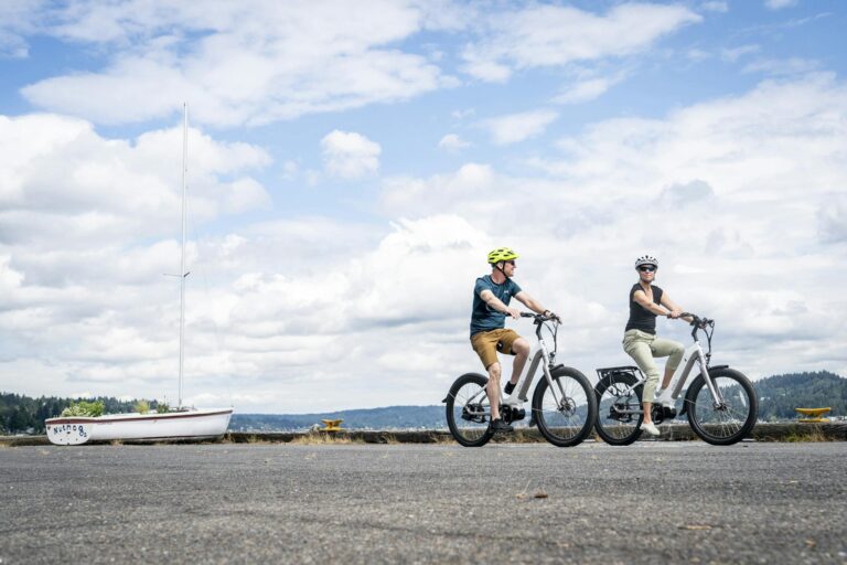 A Couple Wearing Helmets Riding Electric Bikes